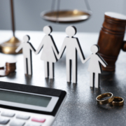 A calculator and family cut-outs on a legal desk, illustrating the data-driven process of a professional maintenance calculation after divorce.